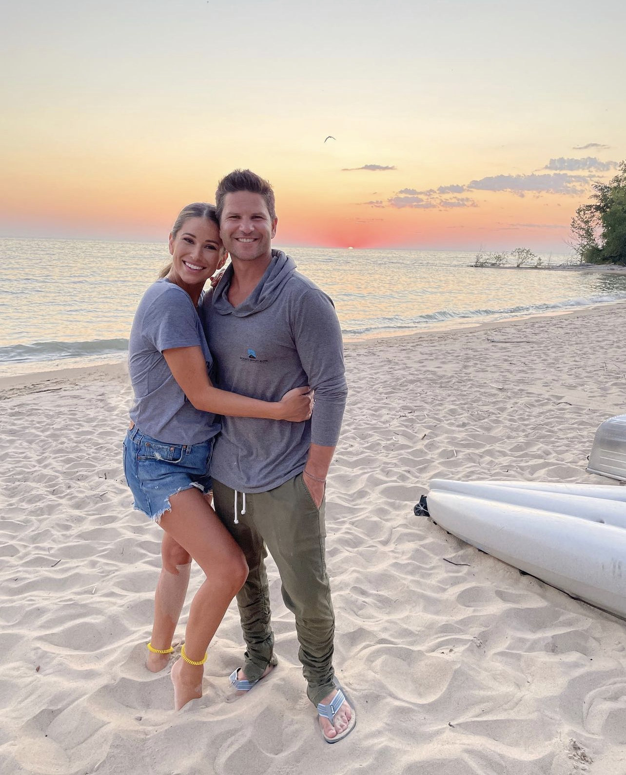 Former Miss USA Nia Sanchez poses for photo with husband and former iCarly star Daniel Booko at sunset on the water in Michigan.