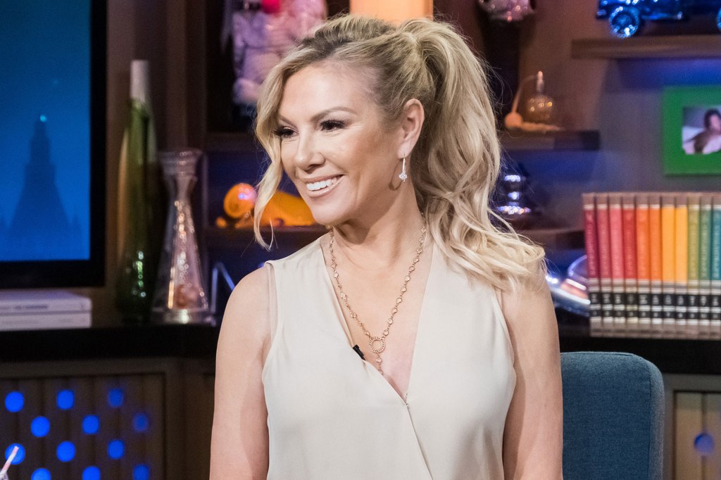 Ramona Singer smiles in nude dress with gold accessories while appearing on Bravo's WWHL